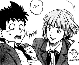 A manga panel of Mamori, a brunette with a bob haircut, leaning over Sena, a short teenage boy with messy, spiky black hair. She straightens Sena's tie as he yelps in surprise. 'Hey, that's too loose!' she says.